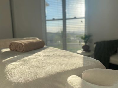 Massage table with towels in a sunlit room.