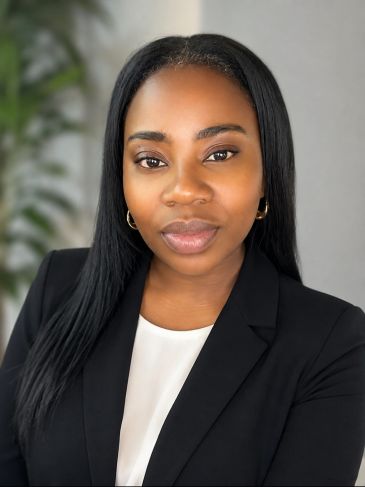 Professional woman in a black blazer and white top.