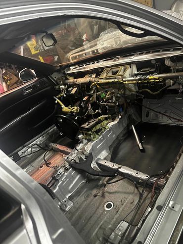 Interior of a car stripped down to its bare metal and wiring.