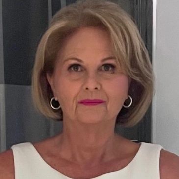 Portrait of a woman with short blonde hair and hoop earrings.