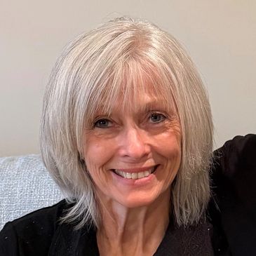 Smiling older woman with grey hair.