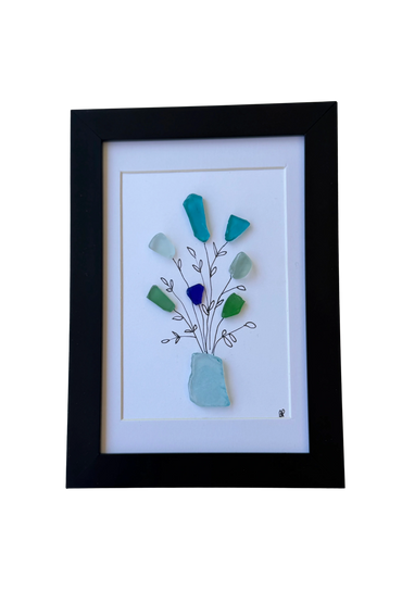 Framed art with sea glass flowers in a vase on white background.