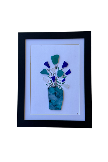 Framed artwork of a vase with sea glass flowers in blue and green hues.