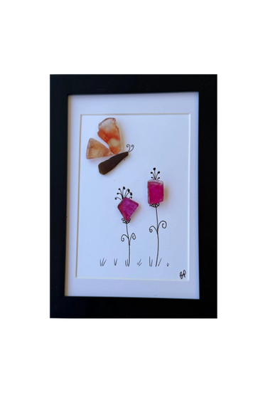 Framed art with sea glass butterfly and flowers on white background.