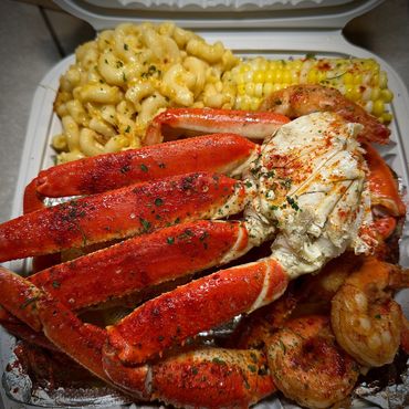 Seafood platter with crab legs, shrimp, corn, and macaroni