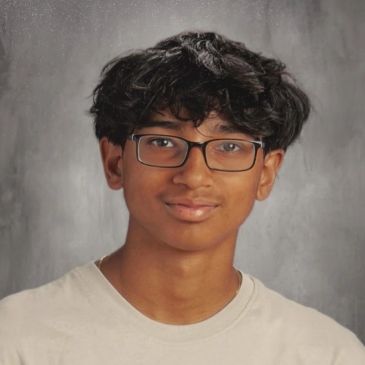 Young man wearing glasses and a light-colored shirt.