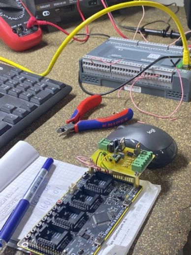 Workspace with electronic components, tools, and a keyboard.