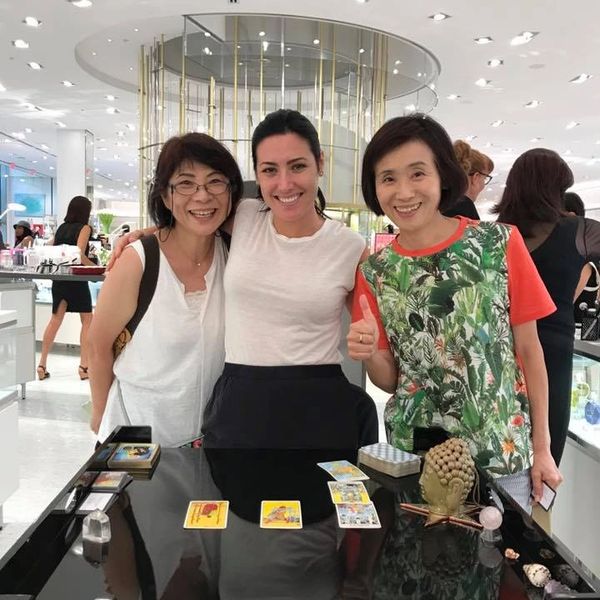 Three women posing for a picture in front of a table.