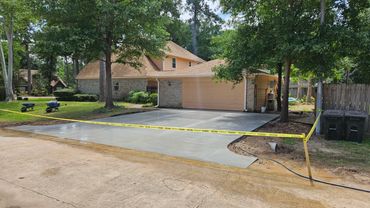 The driveway replacement job was securely taped off to ensure proper curing at a residential site.