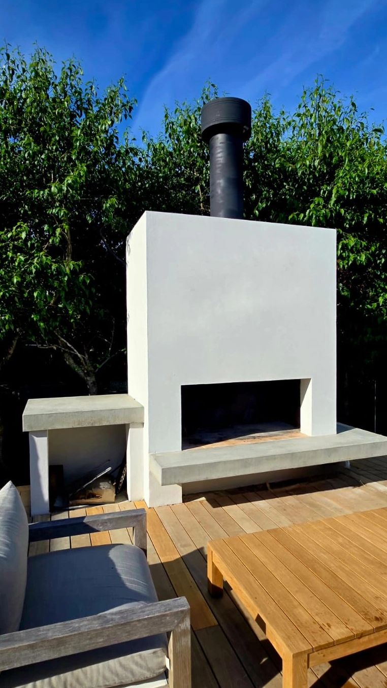 Paint limewash over external render plastered outdoor fireplace.