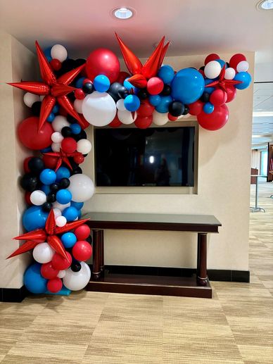 Organic freestanding balloon arch with starburst accents at corporate event  in Birmingham AL