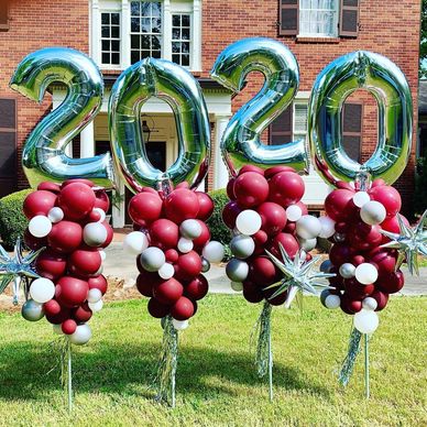 Multi color balloon party poles with large number toppers in yard at in Hoover AL residence.