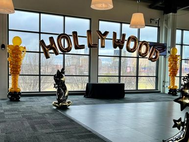 Large Lettered Foil Balloon Arch in windows celebrating awards banquet event.