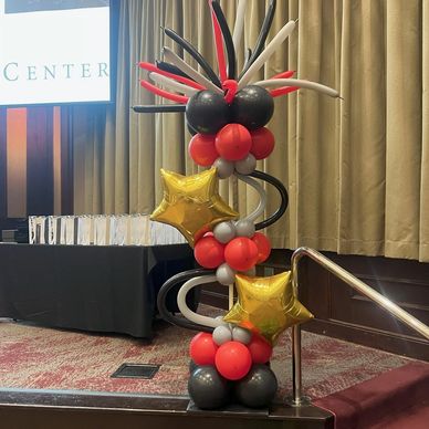 Crazy Hair column with gold stars flanking stage for large event in Birmingham AL.