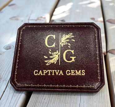 A brown Captiva Gems box with gold letters.