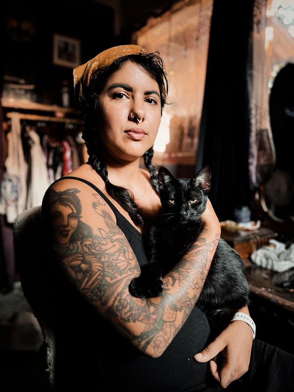 Black cat sitting on the lap of a beautiful brown Arab witch
