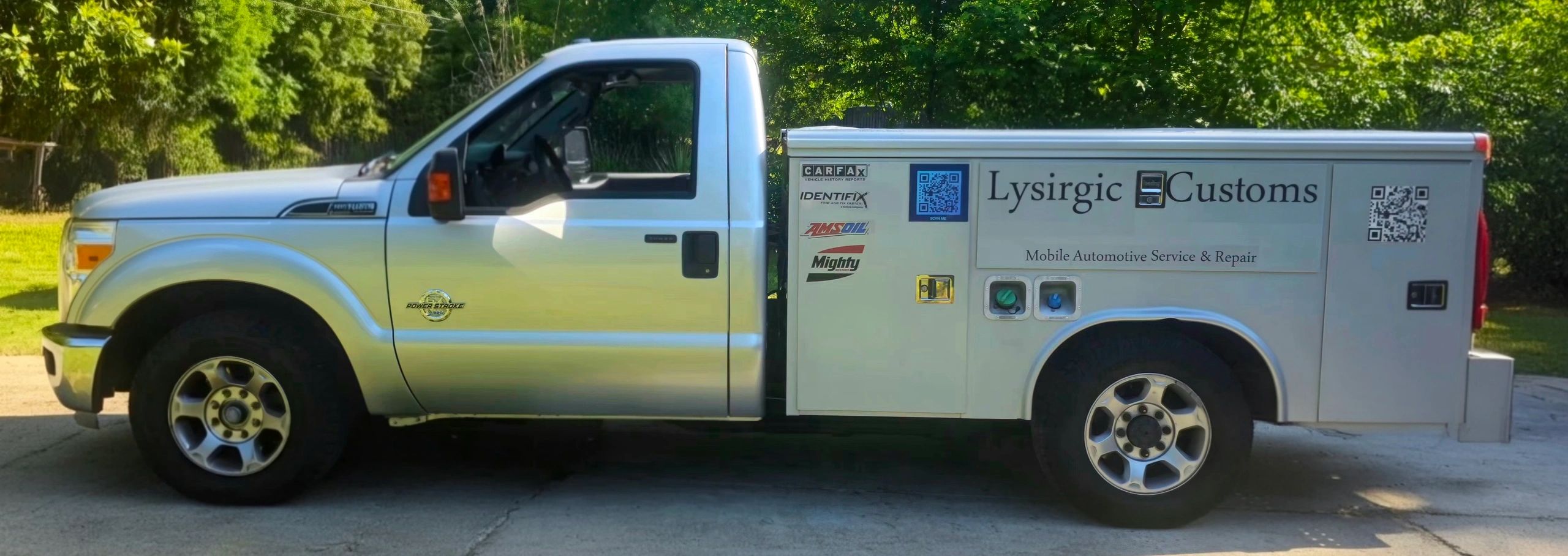 Silver Lysirgic Customs service truck parked outdoors on a sunny day.