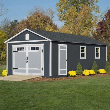 A dark gray storage shed with white trim and double doors in a green yard.