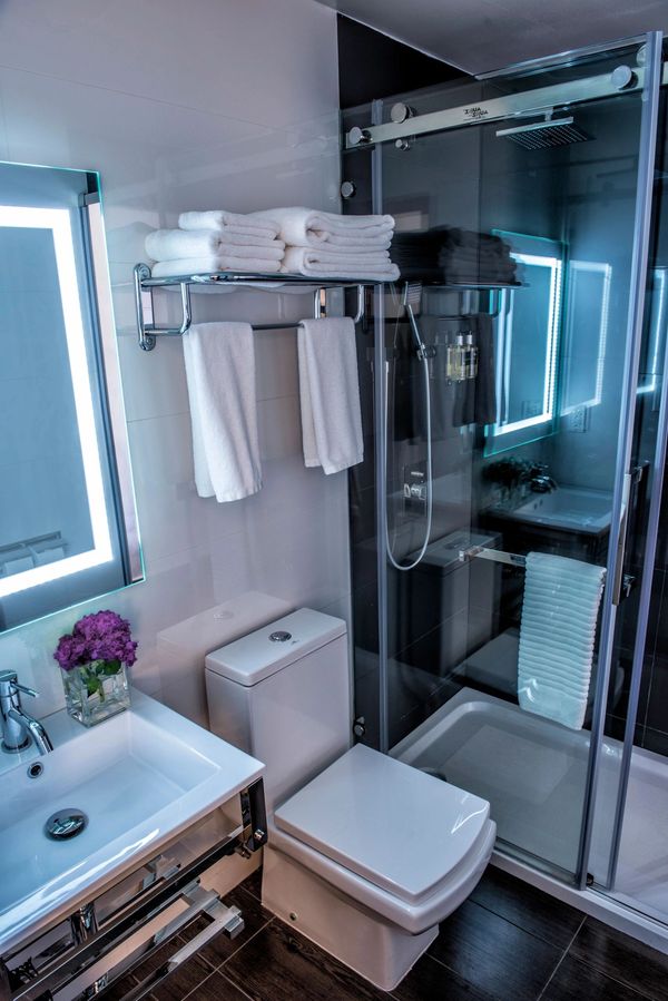 luxurious bathroom with walk-in shower, large towels, fog free mirror.