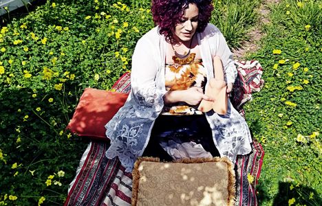 Practitioner using the lingam model for demonstration in the backyard outside in the grass.