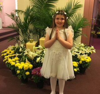 A young girl wearing a white dress at a wedding