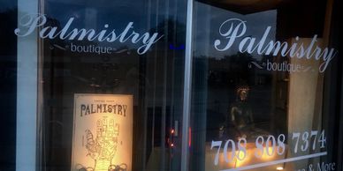 Front window of Palmistry Boutique featuring a Palmistry sign with details on the palm of a hand.