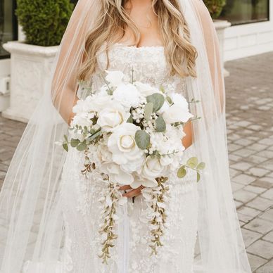 Bride holding a white floral bouquet.