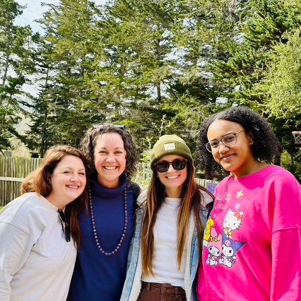 Four smiling teachers with the forest background of the preschool.