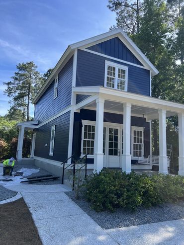 Two-story home with new navy blue exterior paint and white trim