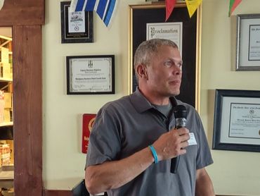 Man speaking into a microphone indoors.