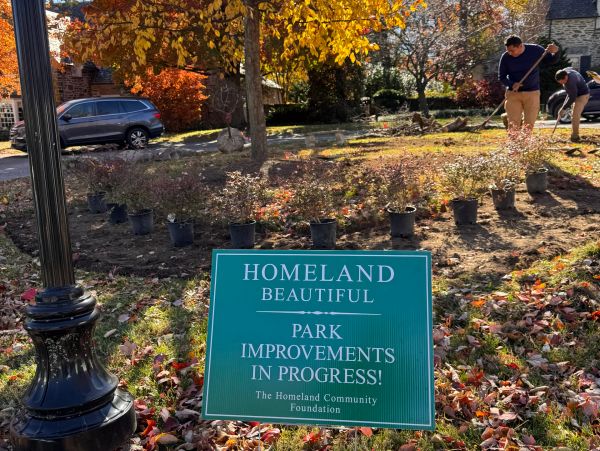 Sign announcing park improvements in progress in a leafy area.