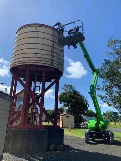 Installation of fairy lights on water tower at large community event.