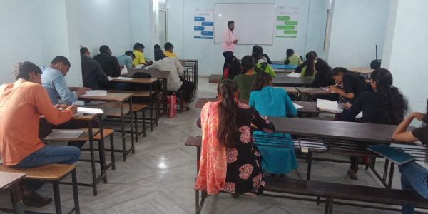 Classroom with students and a teacher at the whiteboard.