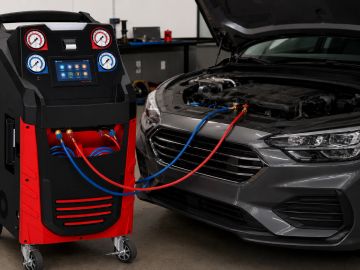 Car connected to diagnostic machine under open hood.