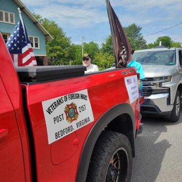 Red truck with Veterans of Foreign Wars signs and flags.