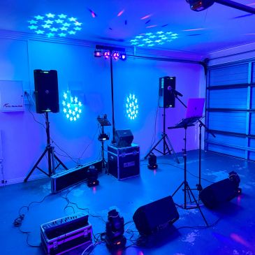 Indoor DJ setup with blue lighting effects.