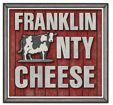Rustic sign for Franklin County Cheese with cow illustration.
