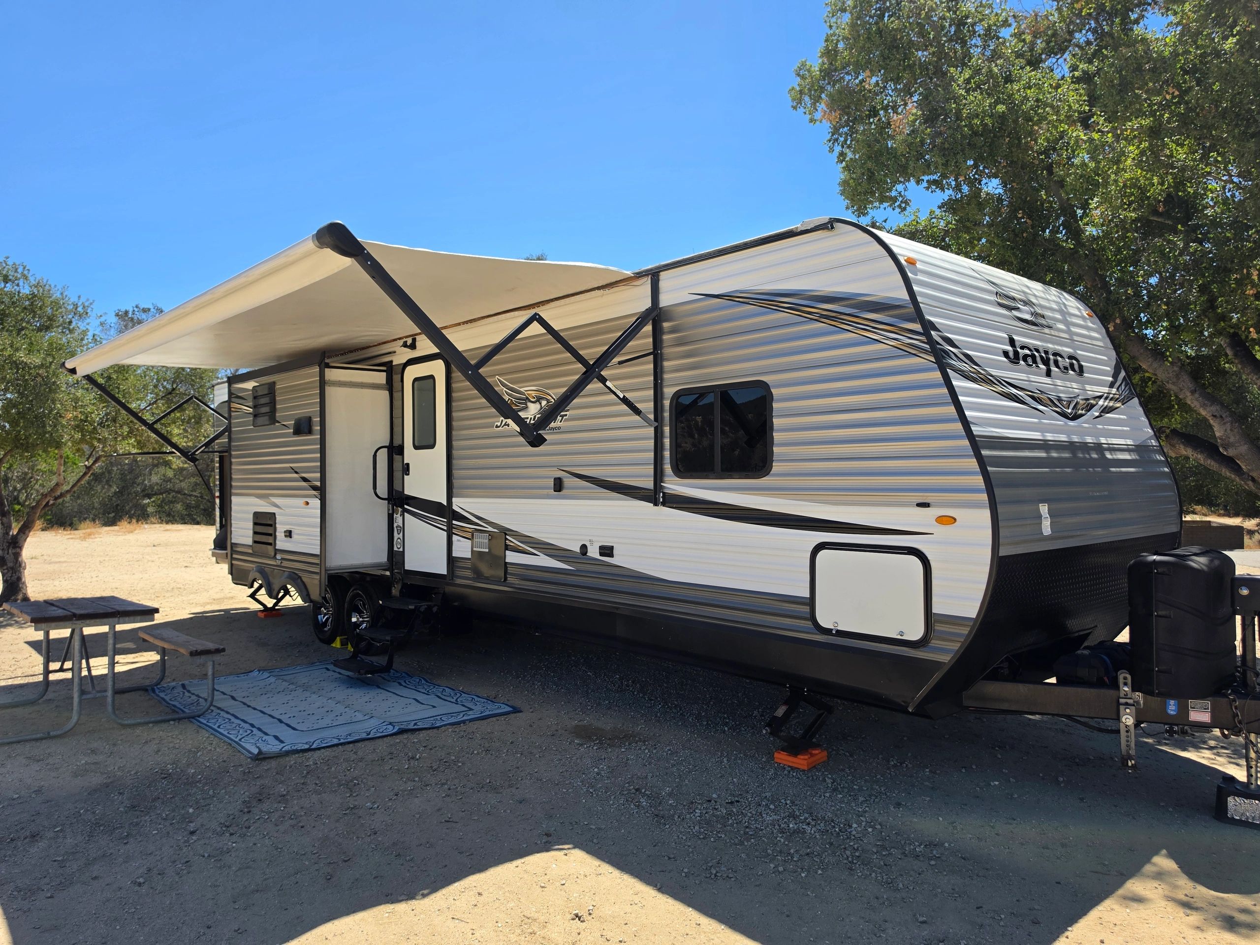 Jayco camper trailer set up in a sunny outdoor area.