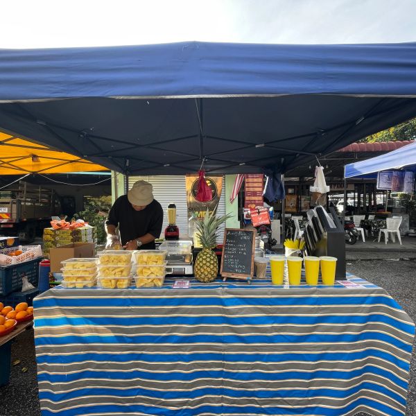Fresh pineapple drink stand at a market.