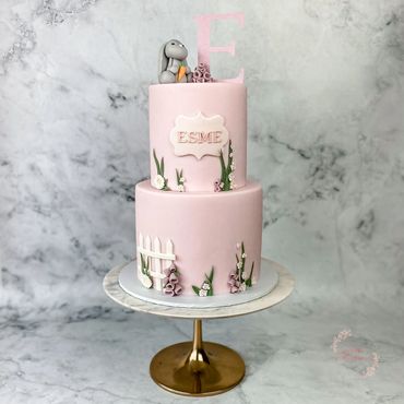 2 tier pink cake with sugar flower decorations, bunny and name plaque