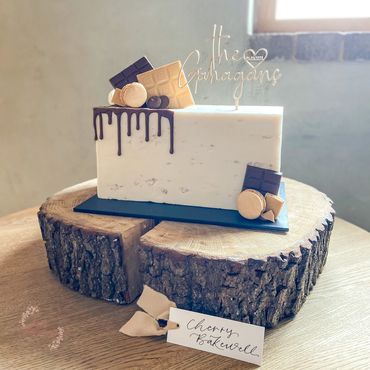 Single tier cake with stone texture decorated with chocolate, gold macarons and chocolate drip