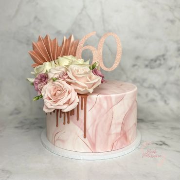 Pink and rose gold marble cake with fresh flower arrangement and 60 topper