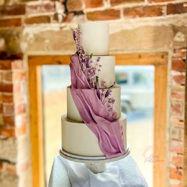 4 tier white wedding cake with lilac cascading pleat, sugar lavender and veronica