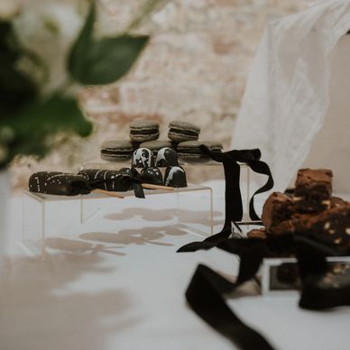 Dessert table display of cakesicles, macarons, bon bons and brownies