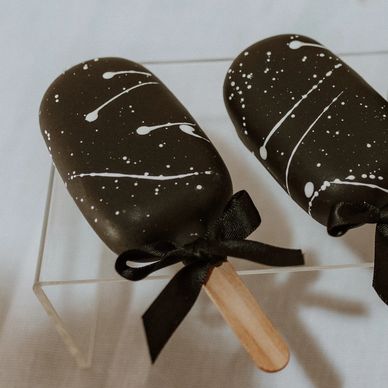 Monochrome display of cakesicles, macarons and bon bons