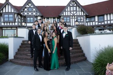 Group of young adults dressed for formal event on steps.