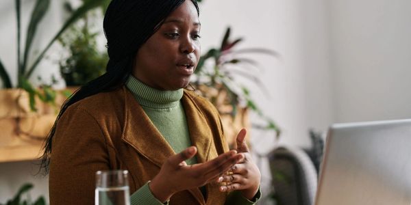 A woman talks passionately during a video call at home.
