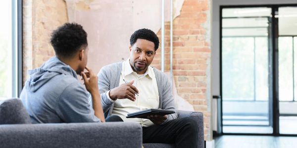 Two men engaged in a serious conversation in a modern office.