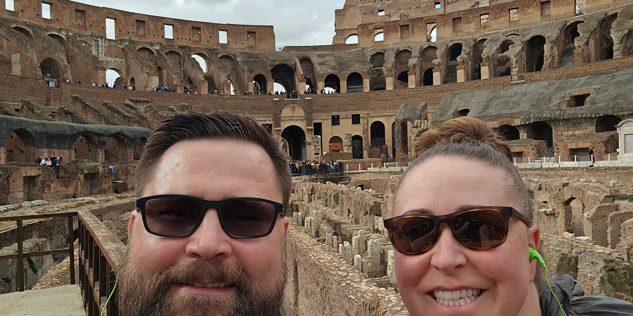 Two people taking a selfie inside the Colosseum in Rome.