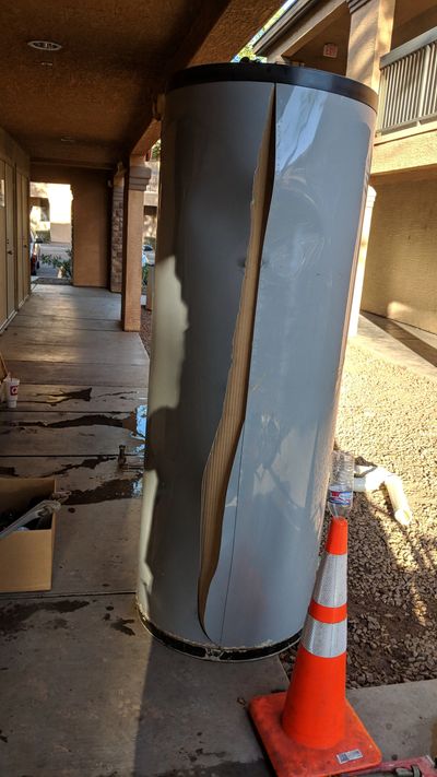 Damaged water heater with a large crack and water leakage.